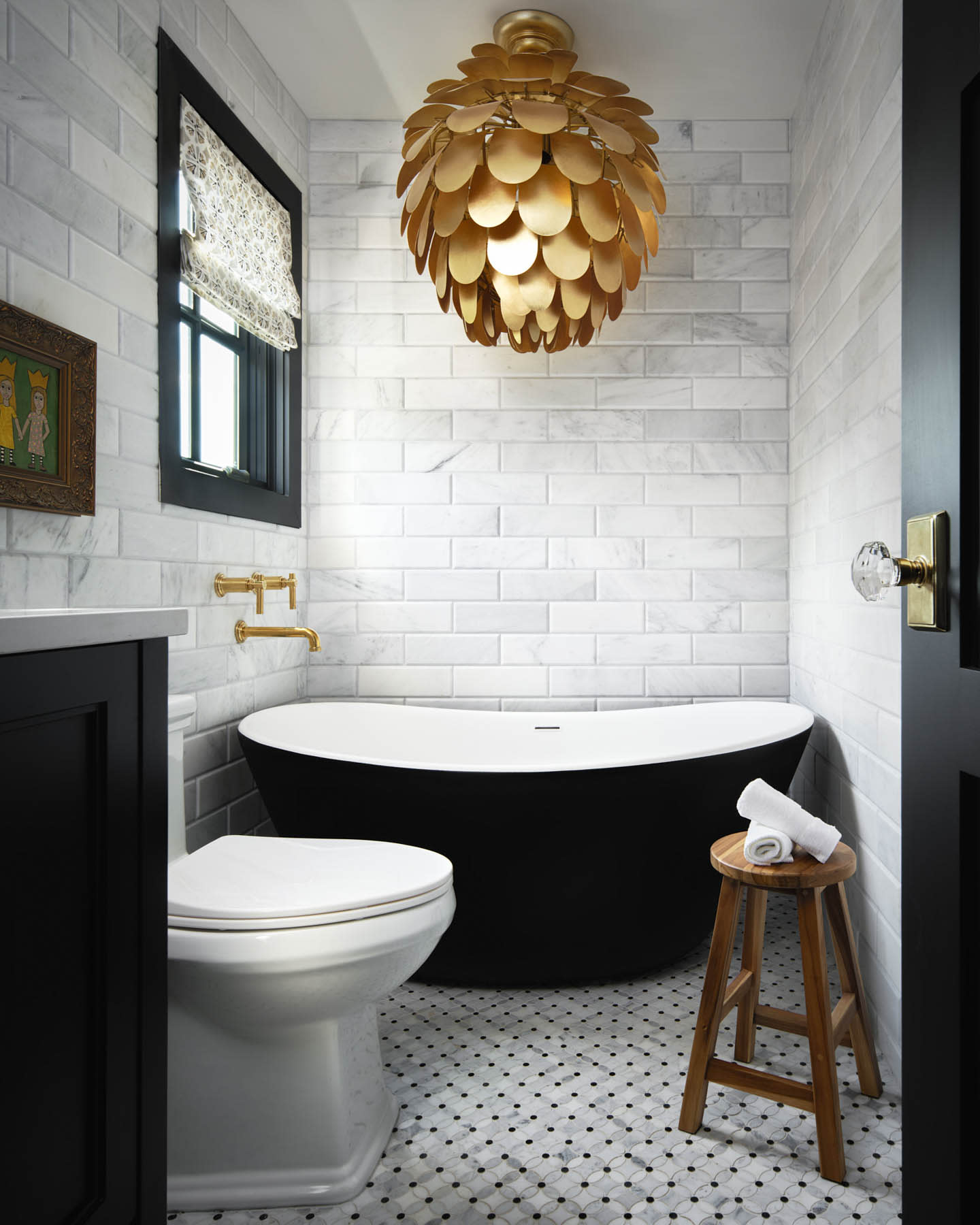white bathroom with a gold light fixture 