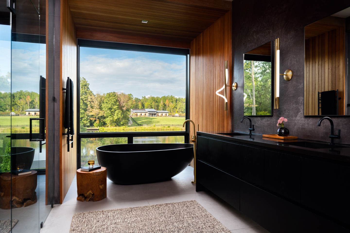 modern bathroom with black finishes and a teak wood wall surrounding the tub