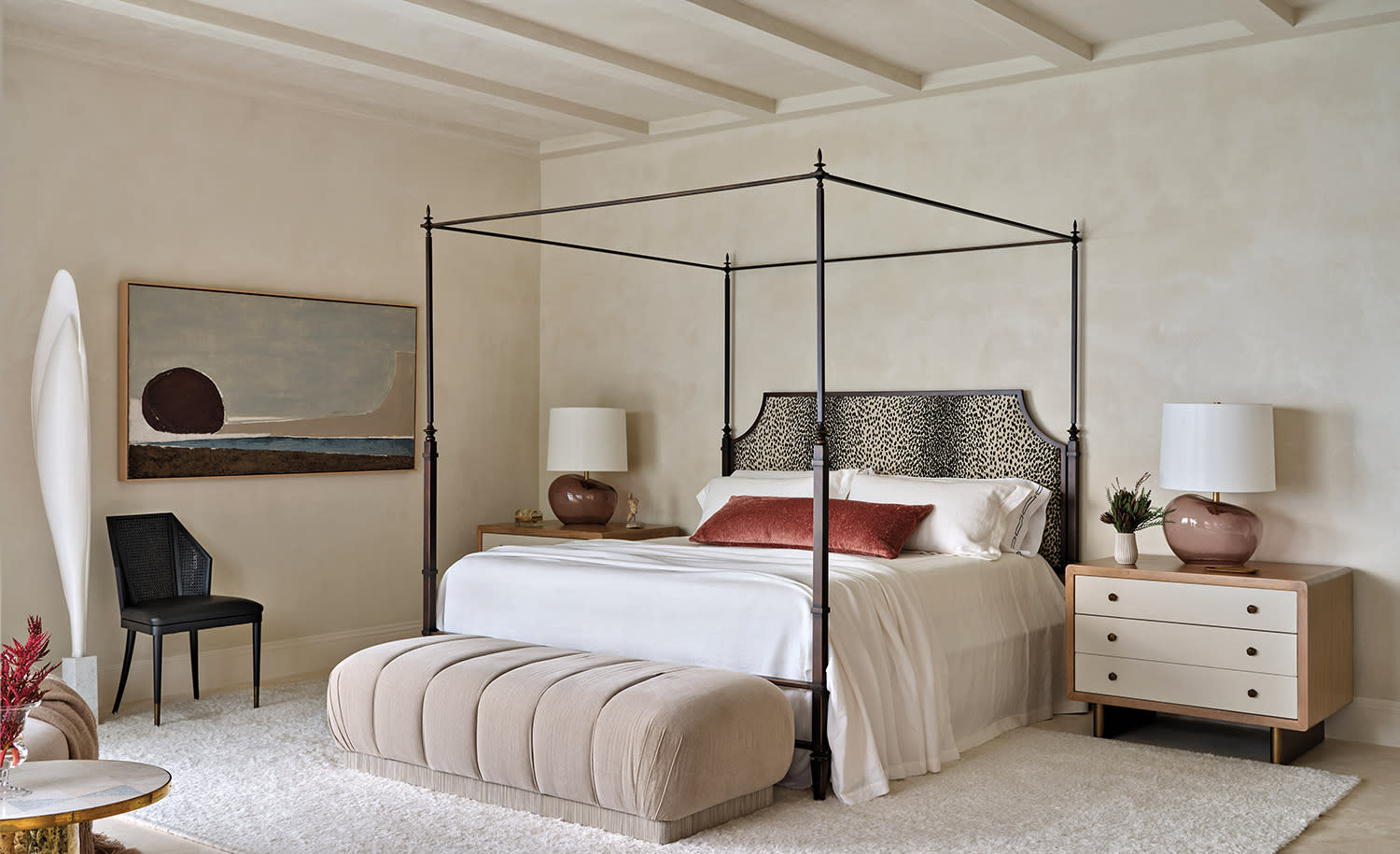 Elegant bedroom with a canopy bed featuring a leopard-print headboard, flanked by wooden nightstands with lamps
